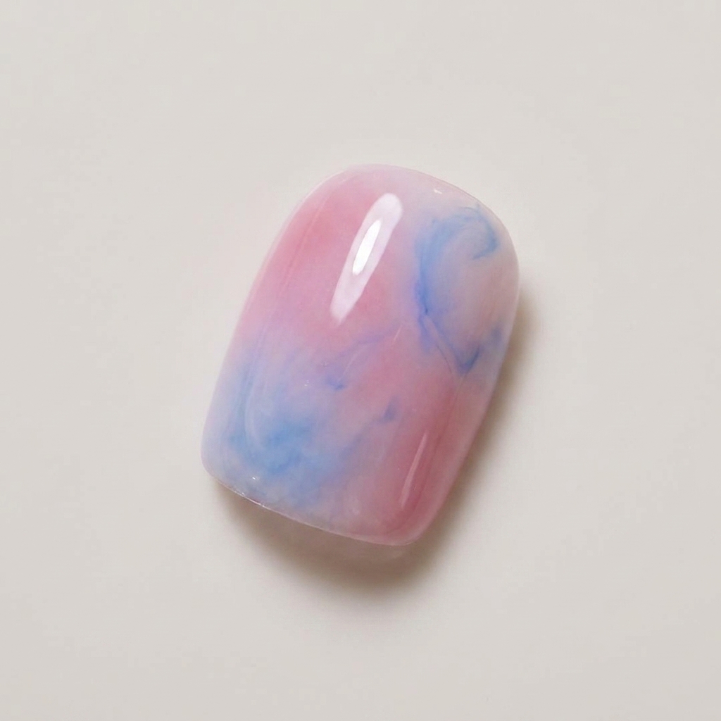 Ein Nagel zeigt eine sanft vermischte Kombination aus Nude-Rosa und hellblauem Gellack.