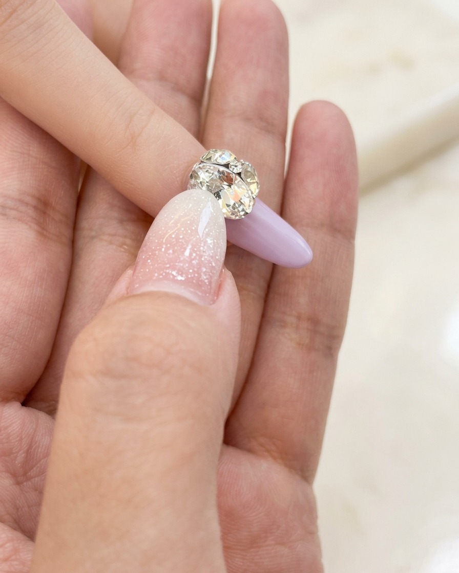 Ein kleiner Nailart-Pinsel trägt eine dünne Schicht klares Basisgel auf den Naturnagel auf.