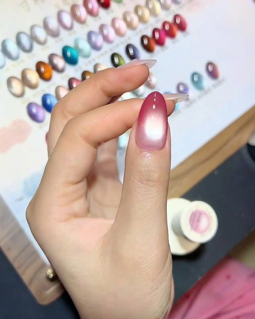 Ein Fingernagel mit Cat-Eye-Effekt härtet unter einer UV-Lampe aus.