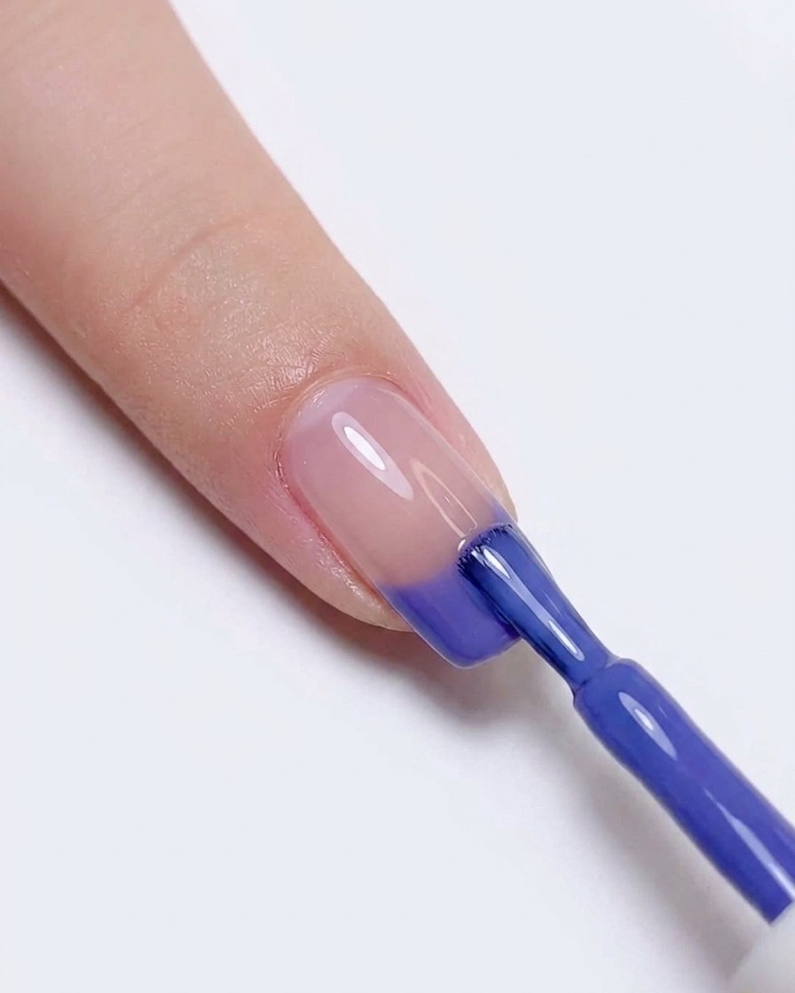 Blaues und violettes Gel wird erneut auf die Nagelspitze aufgetragen, um den Übergang zu verstärken.