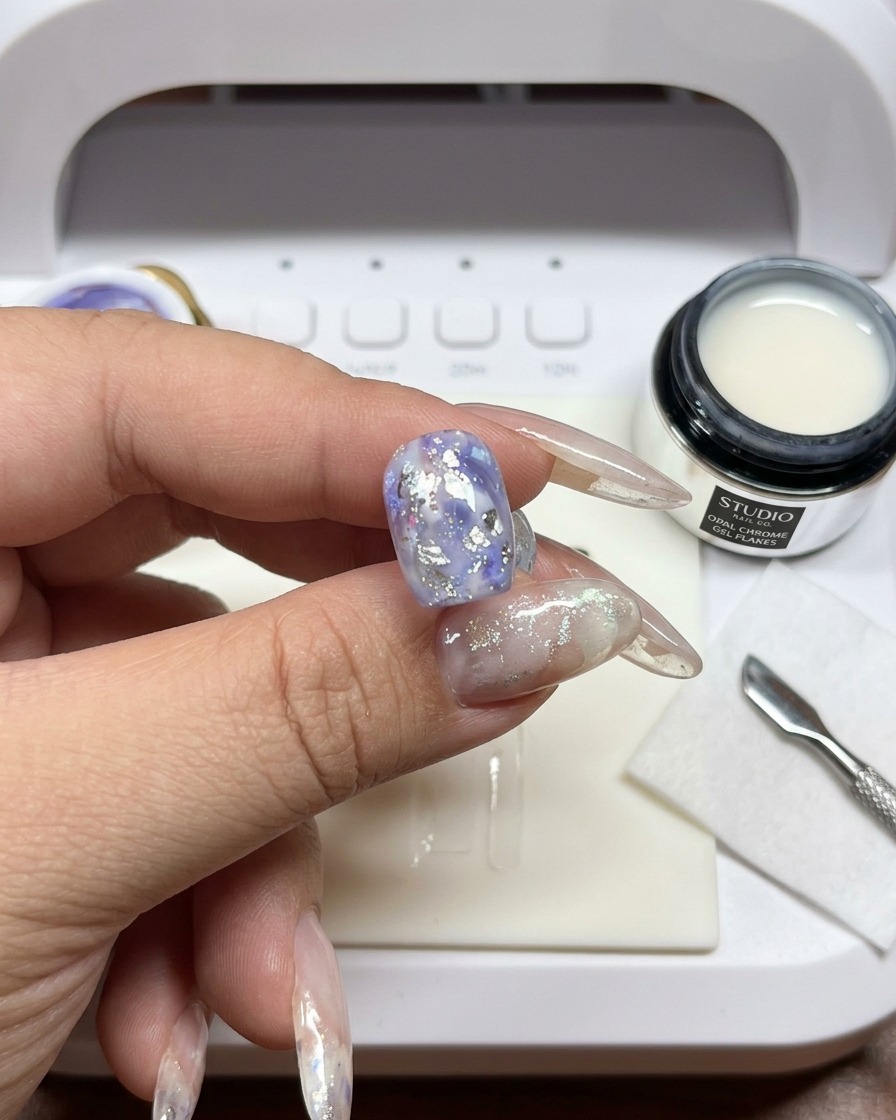 Ein Pinsel wird benutzt, um die Ränder von weißem Gel auf dem Nagel zu verblenden und zu verwischen.