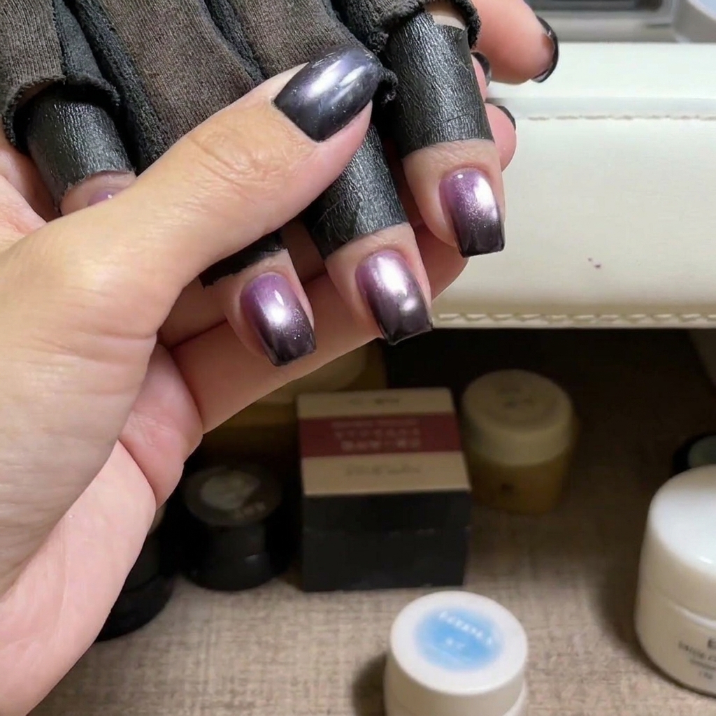 Ein Pinsel trägt blaues Cat-Eye-Gel auf einen Naturnagel auf.