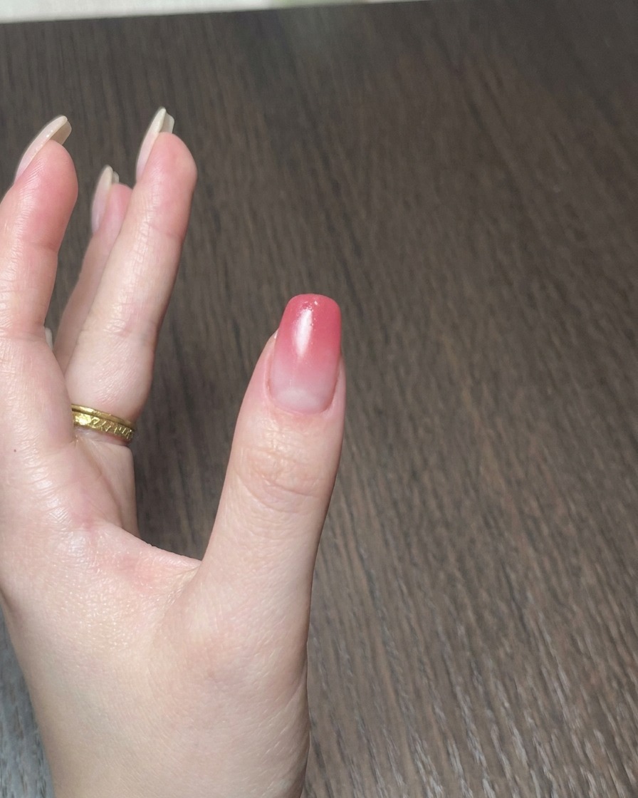 Eine tragbare Mini-Lampe härtet den Gellack auf einem Fingernagel aus.