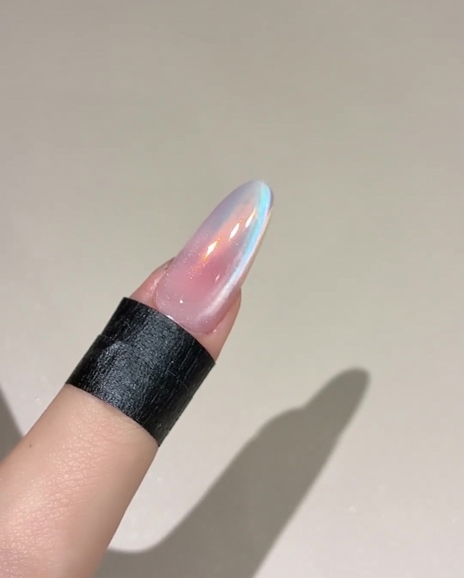 Ein Pinsel trägt eine Schicht Top-Gel auf einen rosafarbenen, ausgehärteten Nagel auf.