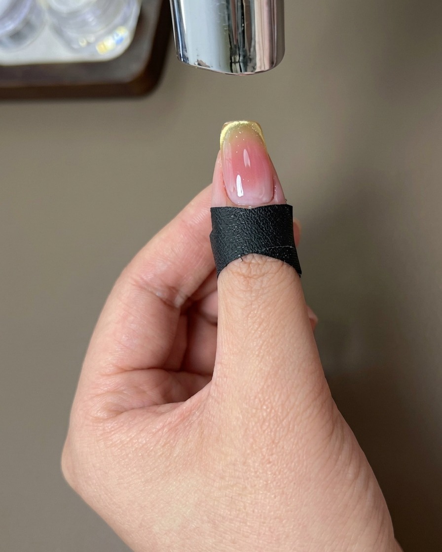 Ein Finger mit dem fertigen Design unter einer UV-Lampe.