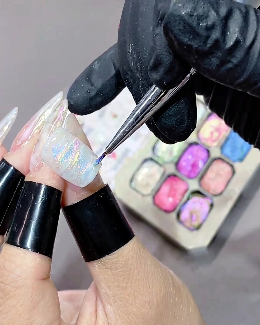 Ein Nagel mit einem frisch aufgetragenen, strukturierten und marmorierten Gel-Design wird in eine UV-Aushärtungslampe gelegt.