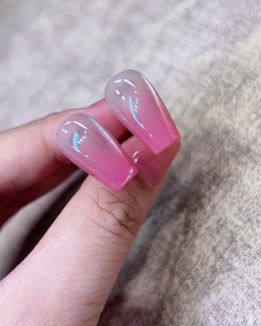 Ein Schwämmchen trägt erneut konzentriertes pinkes Pigment auf die äußerste Nagelspitze auf.