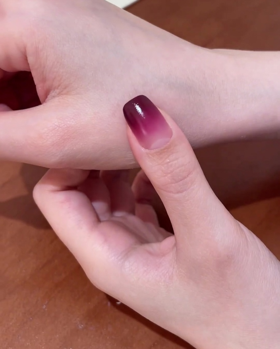 Eine Hand mit Gradient-Basis liegt zur Aushärtung in einer professionellen UV-Nagellampe.