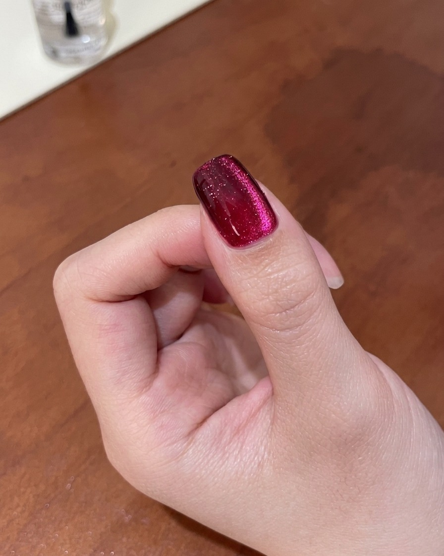 Nahaufnahme eines Nagels, bei dem der magnetische Schimmer mit einem Magneten zu einem tiefen, mehrdimensionalen Verlauf verfeinert wird.