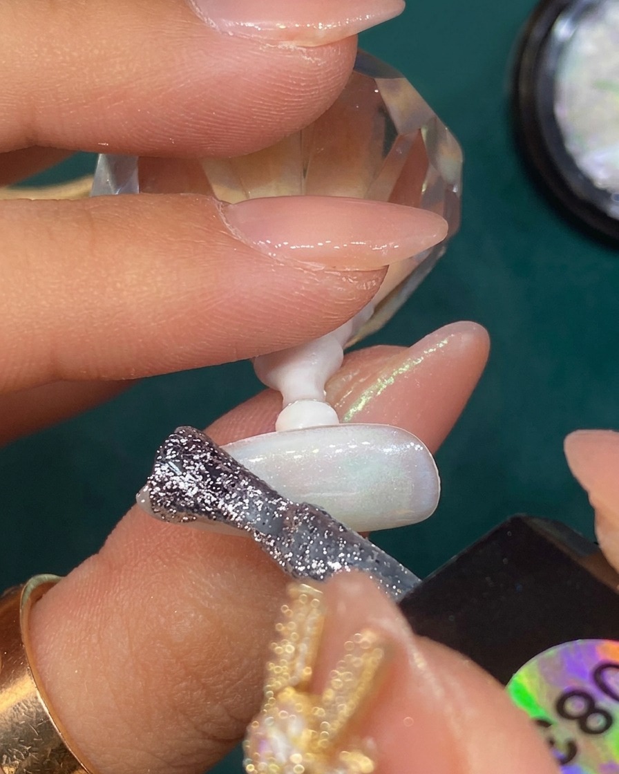 Silbernes Glitzergel wird an der Spitze eines durchscheinenden weißen Nagels zu einem Farbverlauf verblendet.