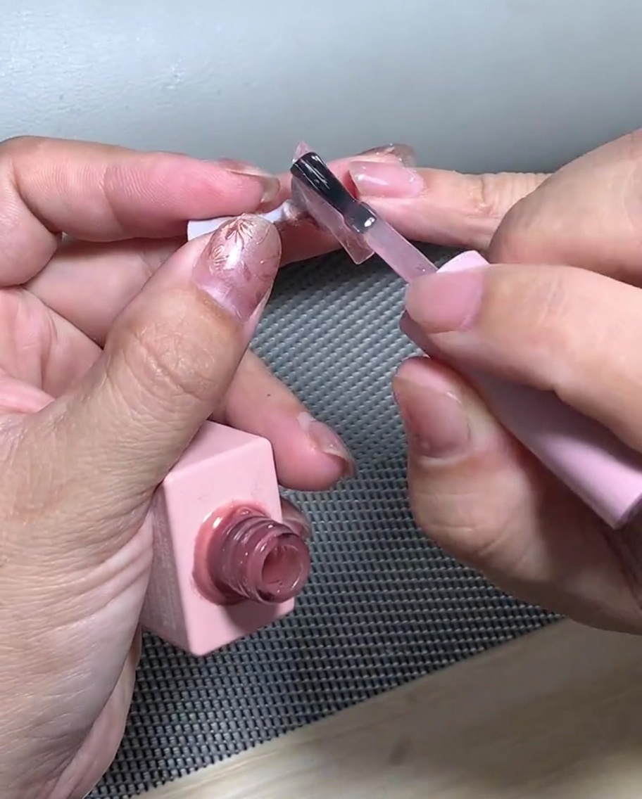 Ein Nagel mit Glitzerverlauf in einer UV-Lampe zum Aushärten.