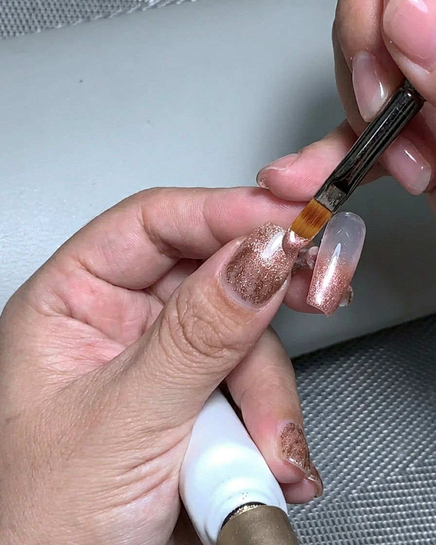 Eine Hand unter einer UV-Lampe beim Aushärten der Aufbaugel-Schicht.