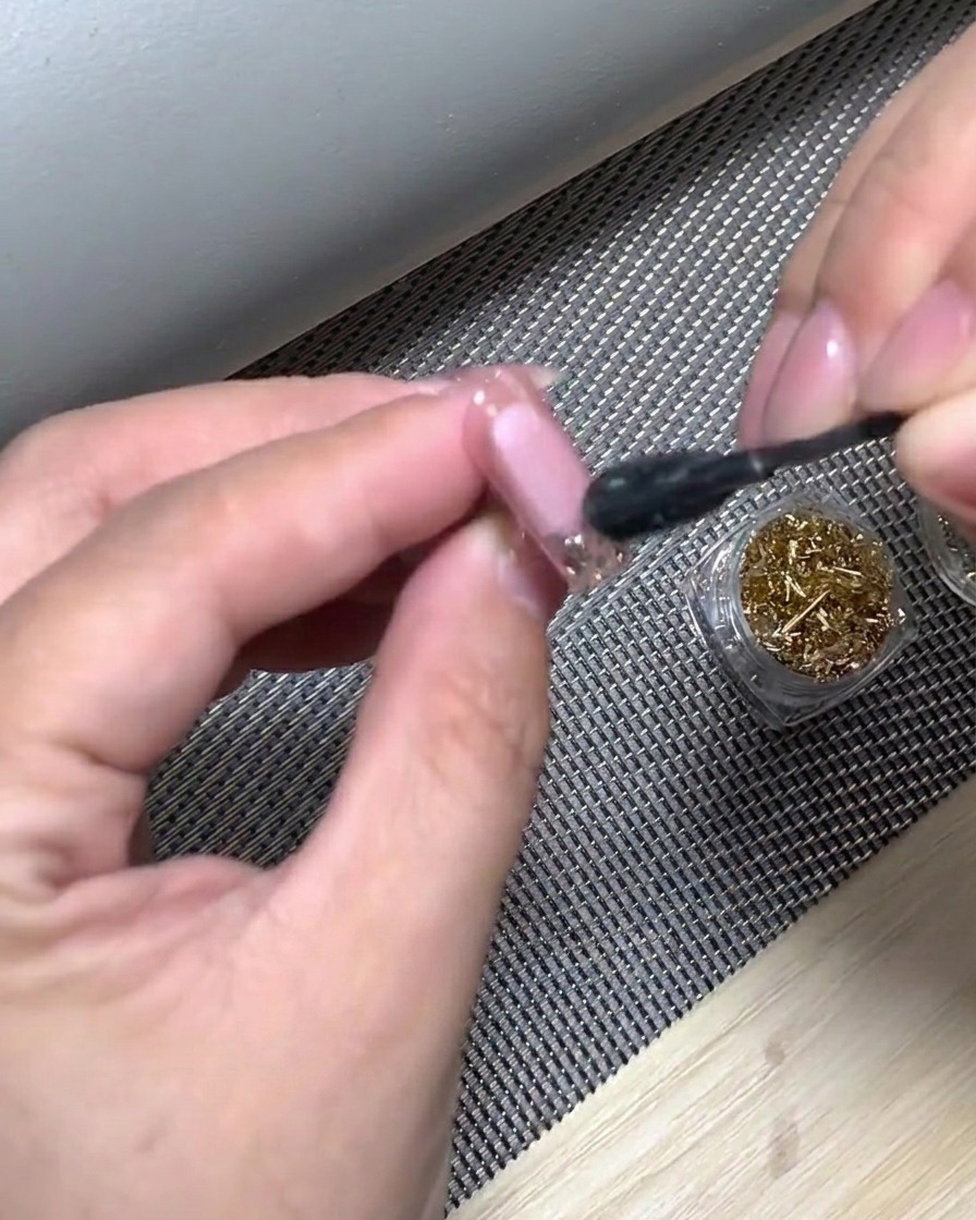 Eine Hand in einer UV-Nagellampe beim Aushärten der frisch aufgetragenen weißen Gradient-Spitze.