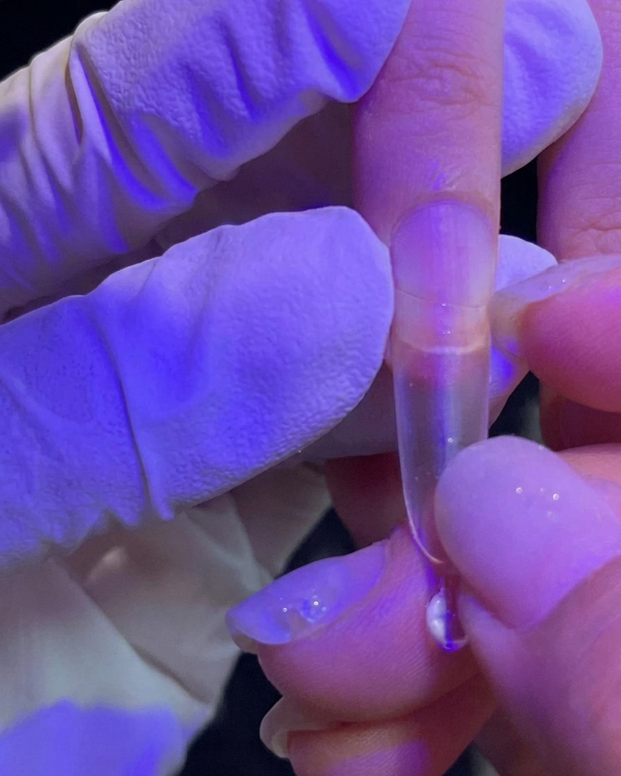 Eine Hand drückt einen durchsichtigen Tip auf den Naturnagel.
