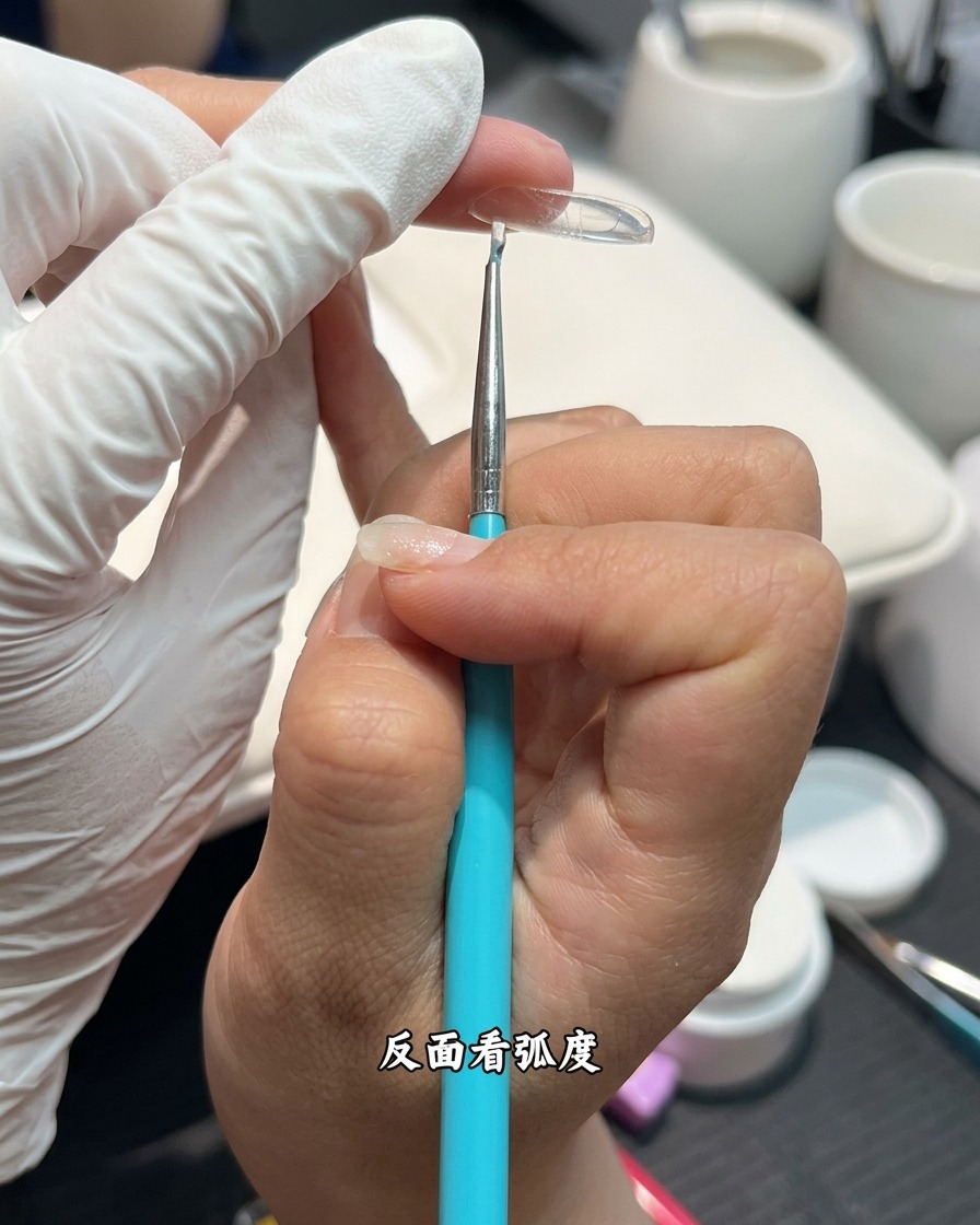 Seitenansicht einer Nagelverlängerung, deren Wölbung und Apex kontrolliert wird.