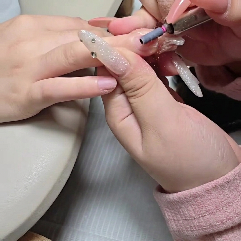 Ein Schleifband an einem Nagelfräser-Aufsatz buffert leicht die natürliche Nagelplatte.
