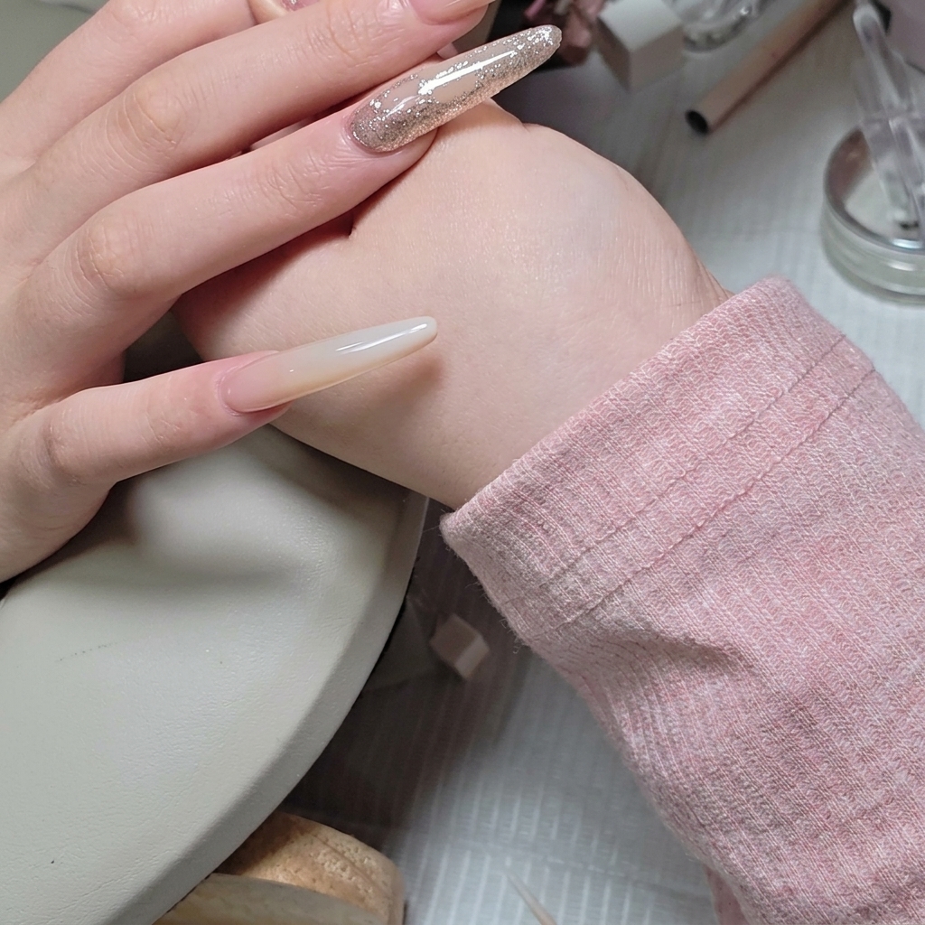 Ein feiner Liner-Pinsel trägt vorsichtig klares Aufbau-Gel um die Kanten einer Strassstein-Anordnung auf.