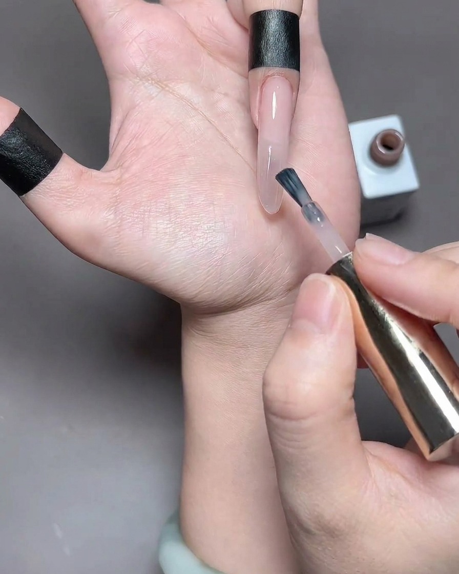 Ein Finger mit frisch aufgetragenem Gel wird zum Aushärten in eine UV-Lampe gelegt.