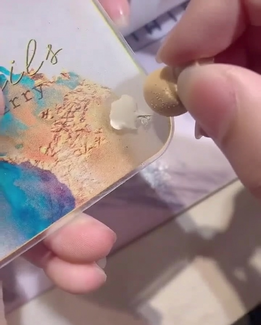 Nahaufnahme eines weißen Make-up-Schwämmchens, das mit weißem Gel von einer Palette aufgenommen wird.