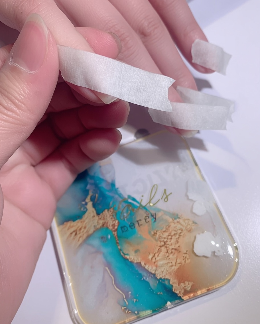 Ein Schwamm tupft weißes Gel auf die Nagelspitze, um einen Ombré-Effekt zu erzeugen.