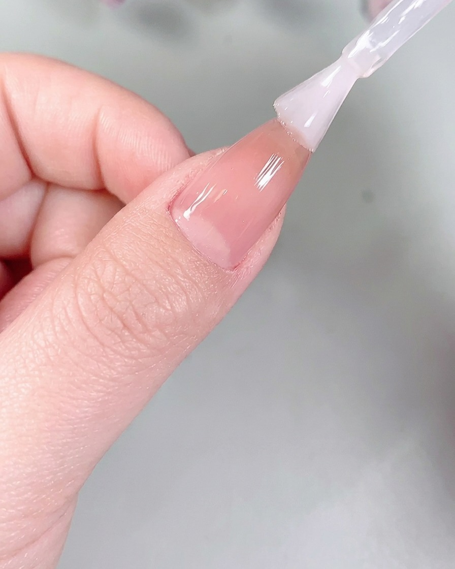 Fingernägel, die zum Aushärten in einer professionellen UV/LED-Nagellampe liegen.