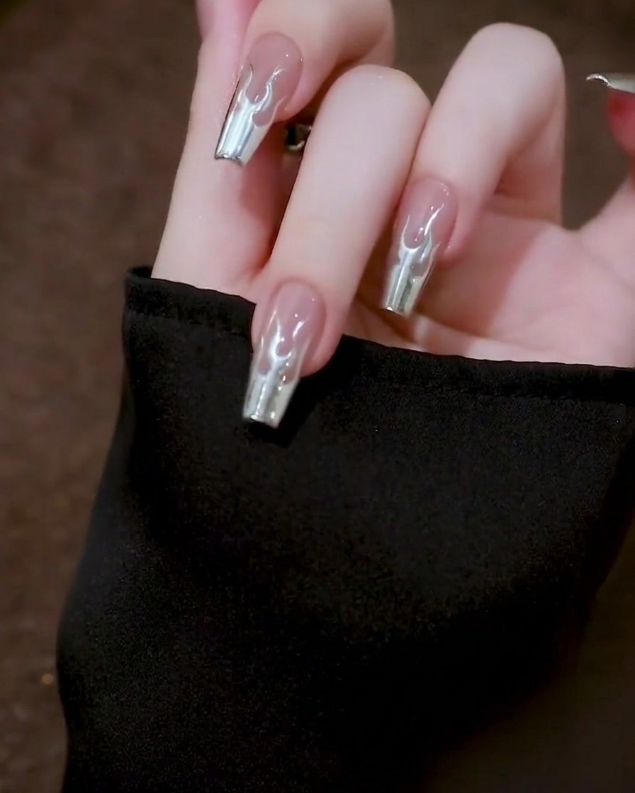 Draufsicht auf eine Hand, die einen Nagel ruhig hält, während das Metallic-Gel auf der Nageloberfläche zu einem glatten Finish verläuft.