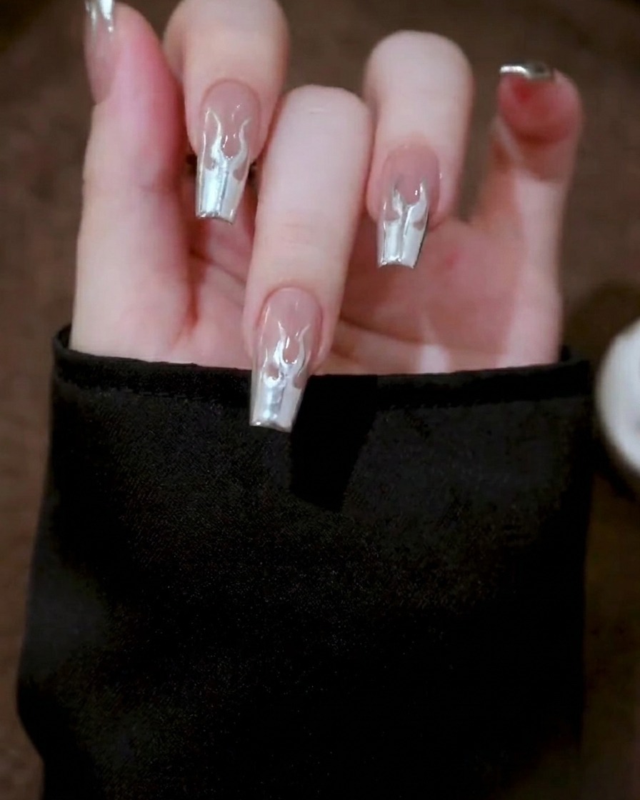 Nahaufnahme einer Hand in einer professionellen Nagellampe während des Aushärtungsprozesses des Metallic-Gel-Designs.
