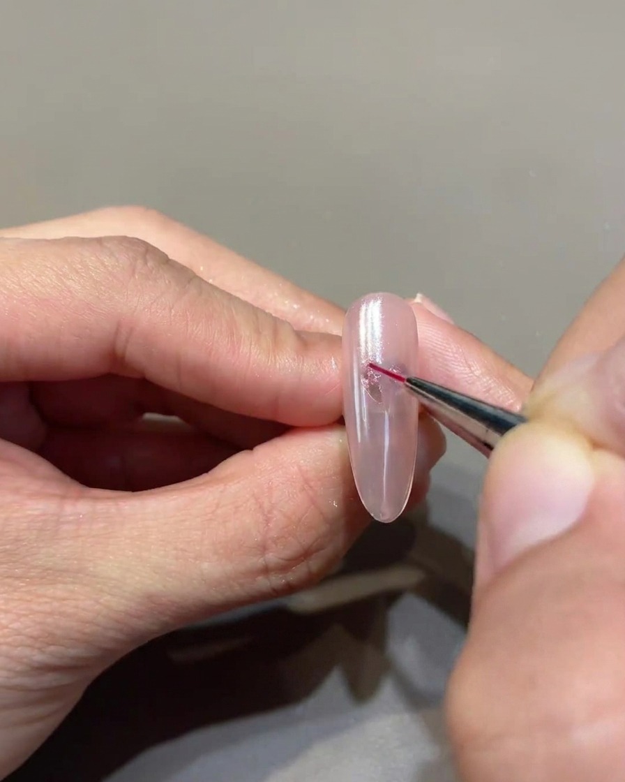 Ein feiner Liner-Pinsel verbindet die Geltupfen zu einer scharfen Herzform.