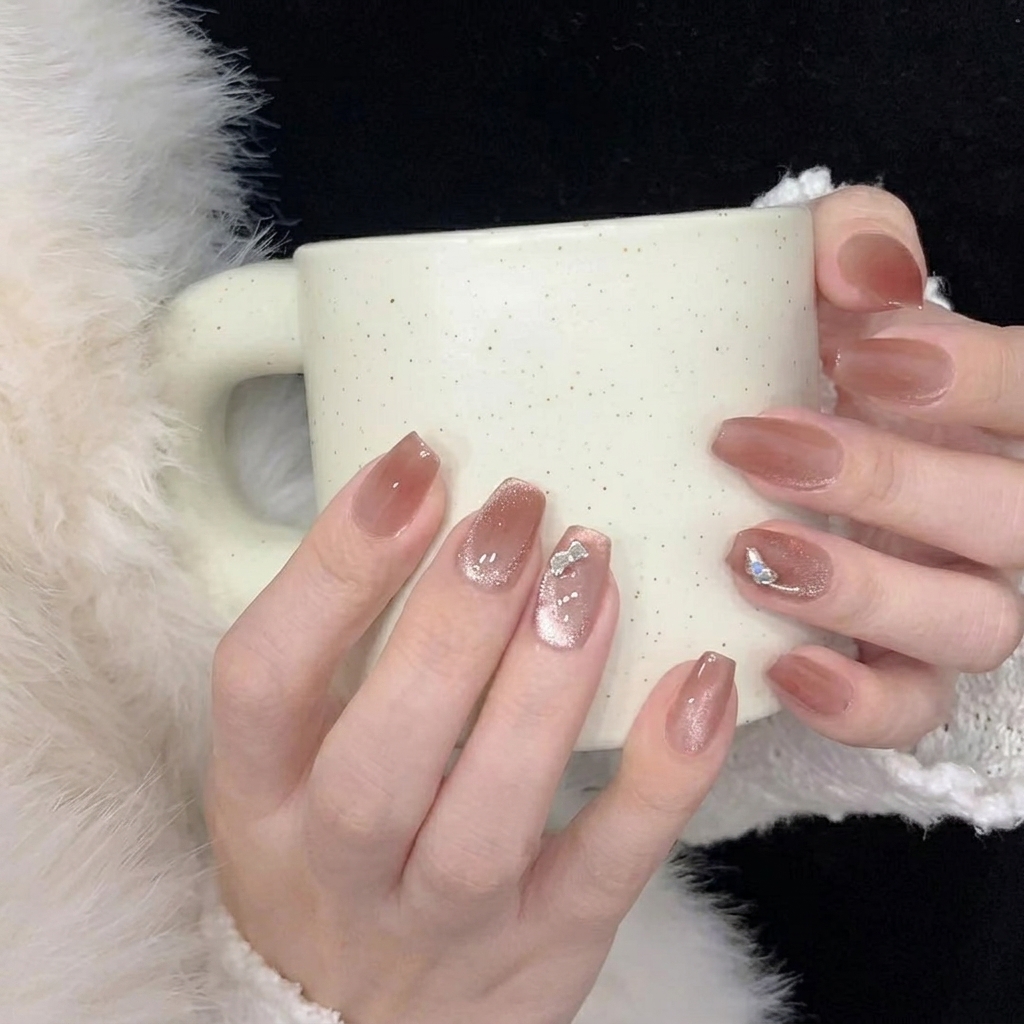 Daumen und Zeigefinger drücken fest auf die Mitte und die Seiten eines neu angebrachten Press-on Nagels.