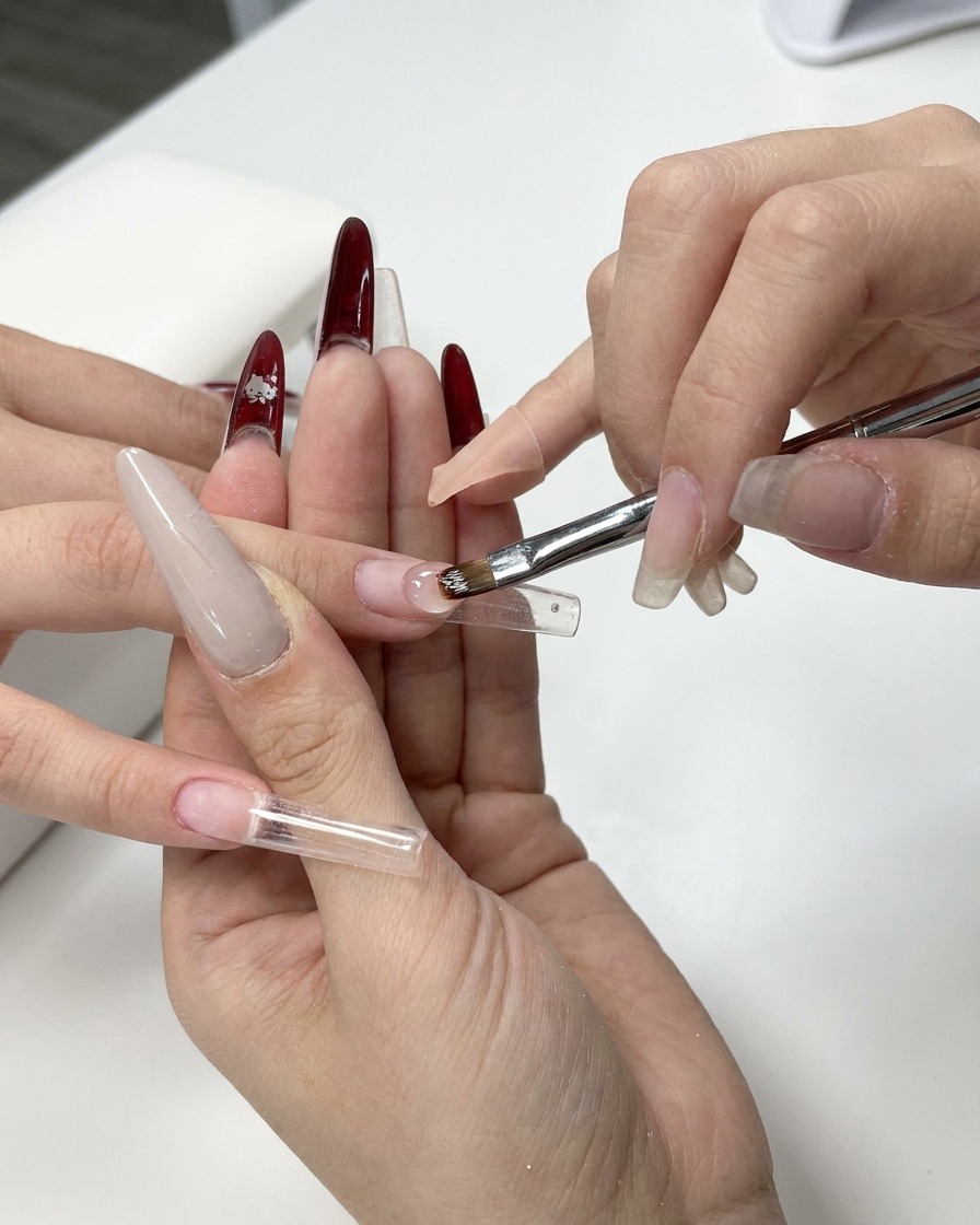 Nahaufnahme eines Gelpinsels, der klares Aufbau-Gel auf eine Nagelschablone aufträgt.
