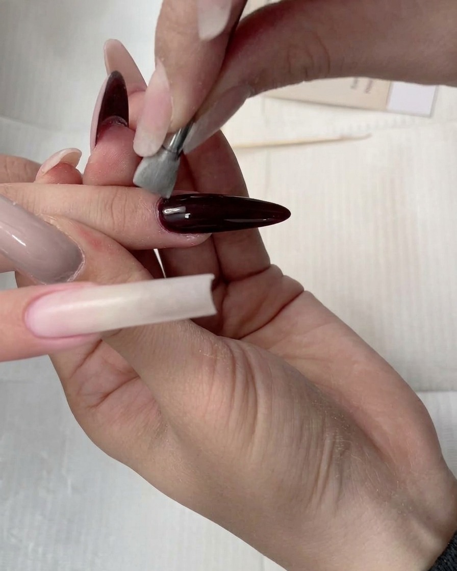 Der Schwammapplikator verblendet das Concealer-Gel entlang der Nagellänge.