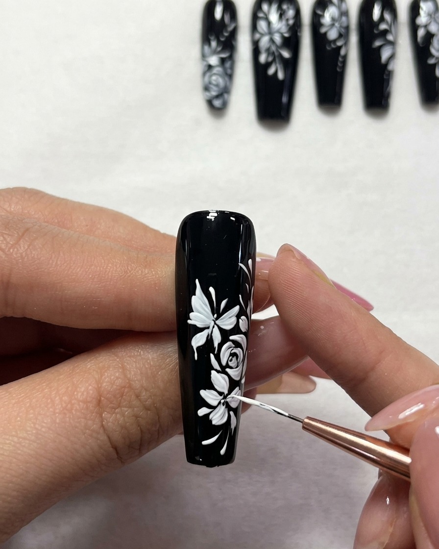 Nahaufnahme, wie kleine weiße Punkte zur Dekoration auf das florale Design gesetzt werden.