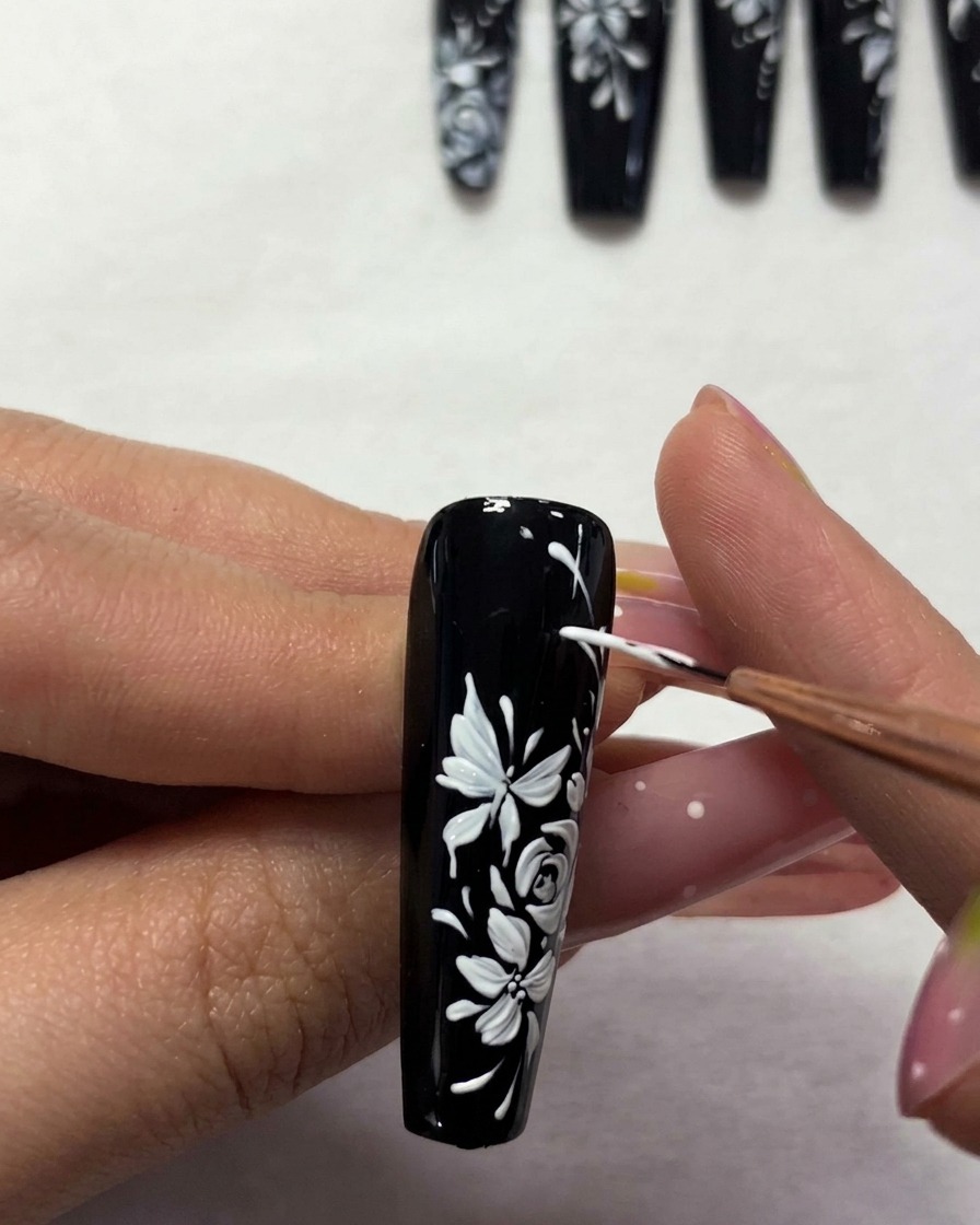 Ein Pinsel trägt klaren Top Coat auf das fertige Design auf.