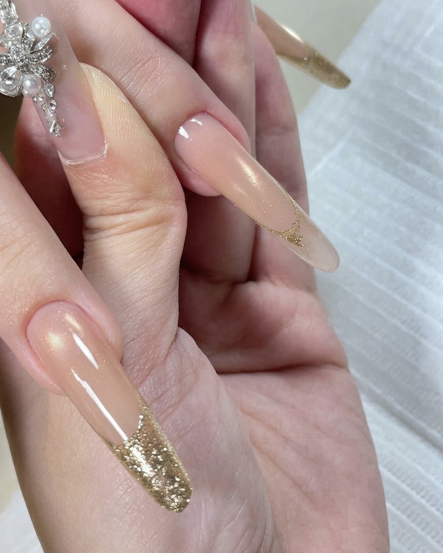 Eine Hand in der LED-Lampe, während die Nagelspitzen durch das Licht ausgehärtet werden.