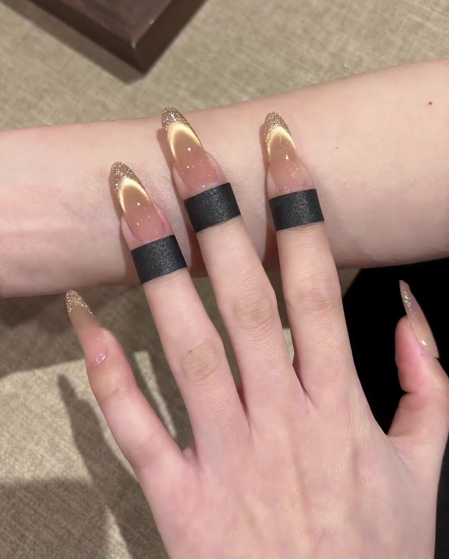 Nahaufnahme einer Hand mit fertigen French-Maniküre-Details, die in einer UV/LED-Lampe ausgehärtet werden.