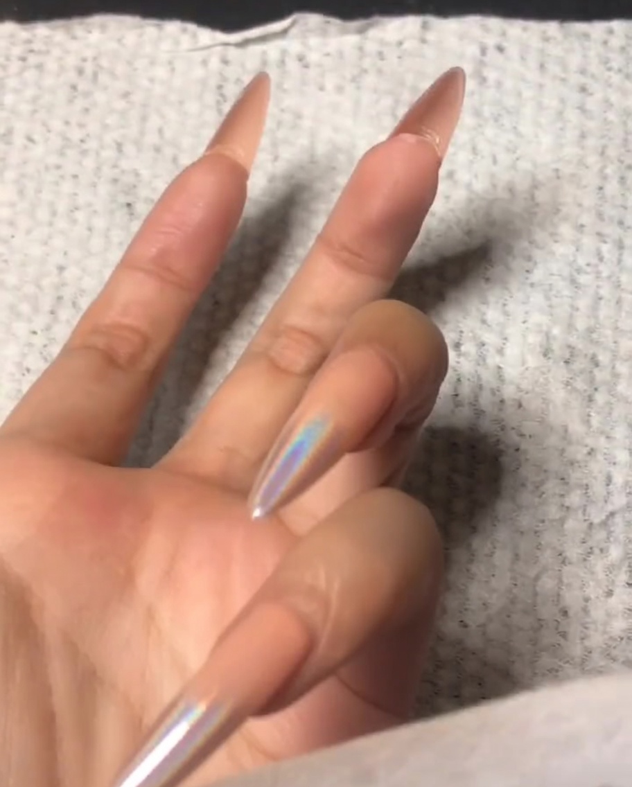 Eine Hand benutzt einen kleinen Buffer, um den vorderen Rand eines Zeigefingers zu feilen.