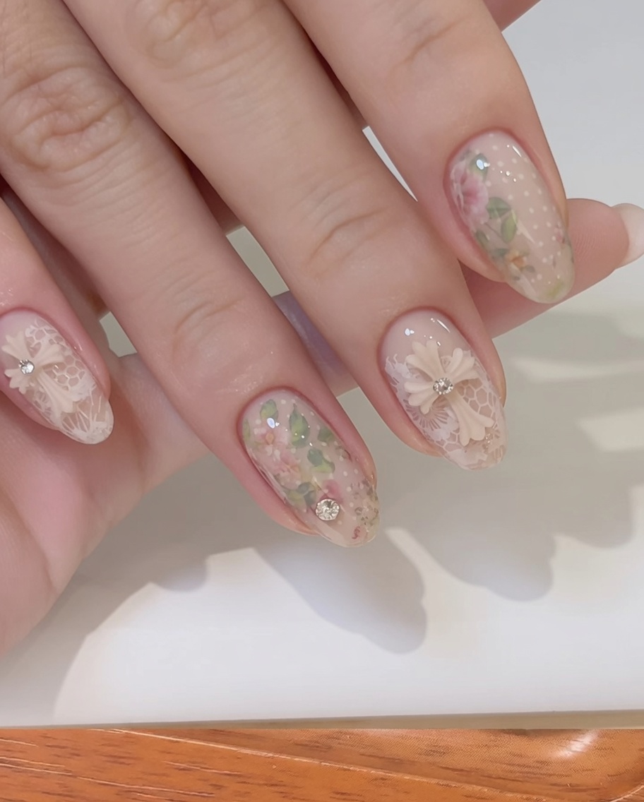 Ein feinhaariger Pinsel glättet Aufbaugel um einen 3D-Schleifen-Charm auf einem Fingernagel.