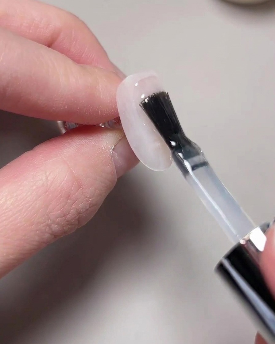Eine Hand befindet sich in einer UV/LED-Nagellampe zum Aushärten.