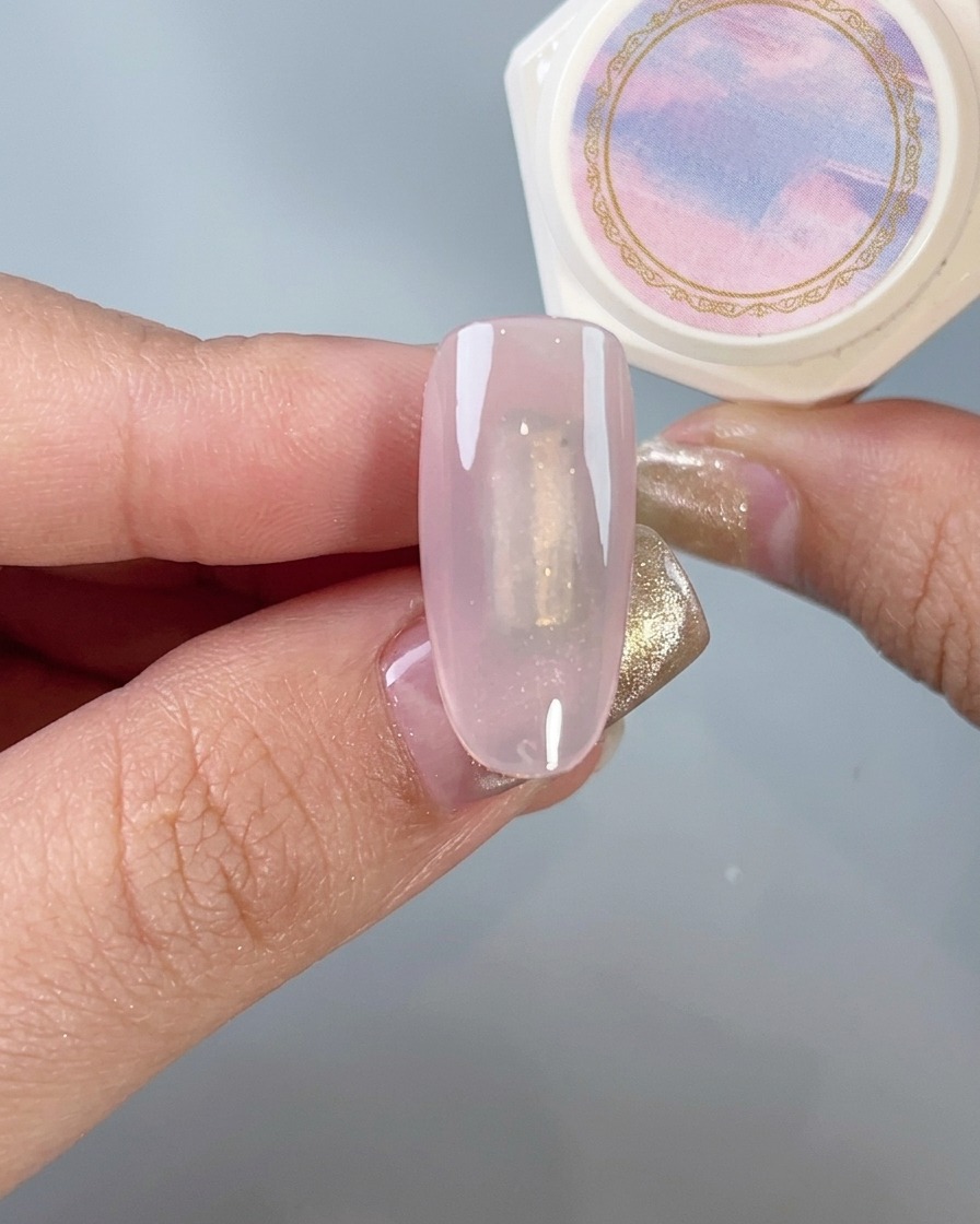Ein weicher Pinsel staubt sanft überschüssiges Chrome-Puder von einem manikürten Nagel ab.