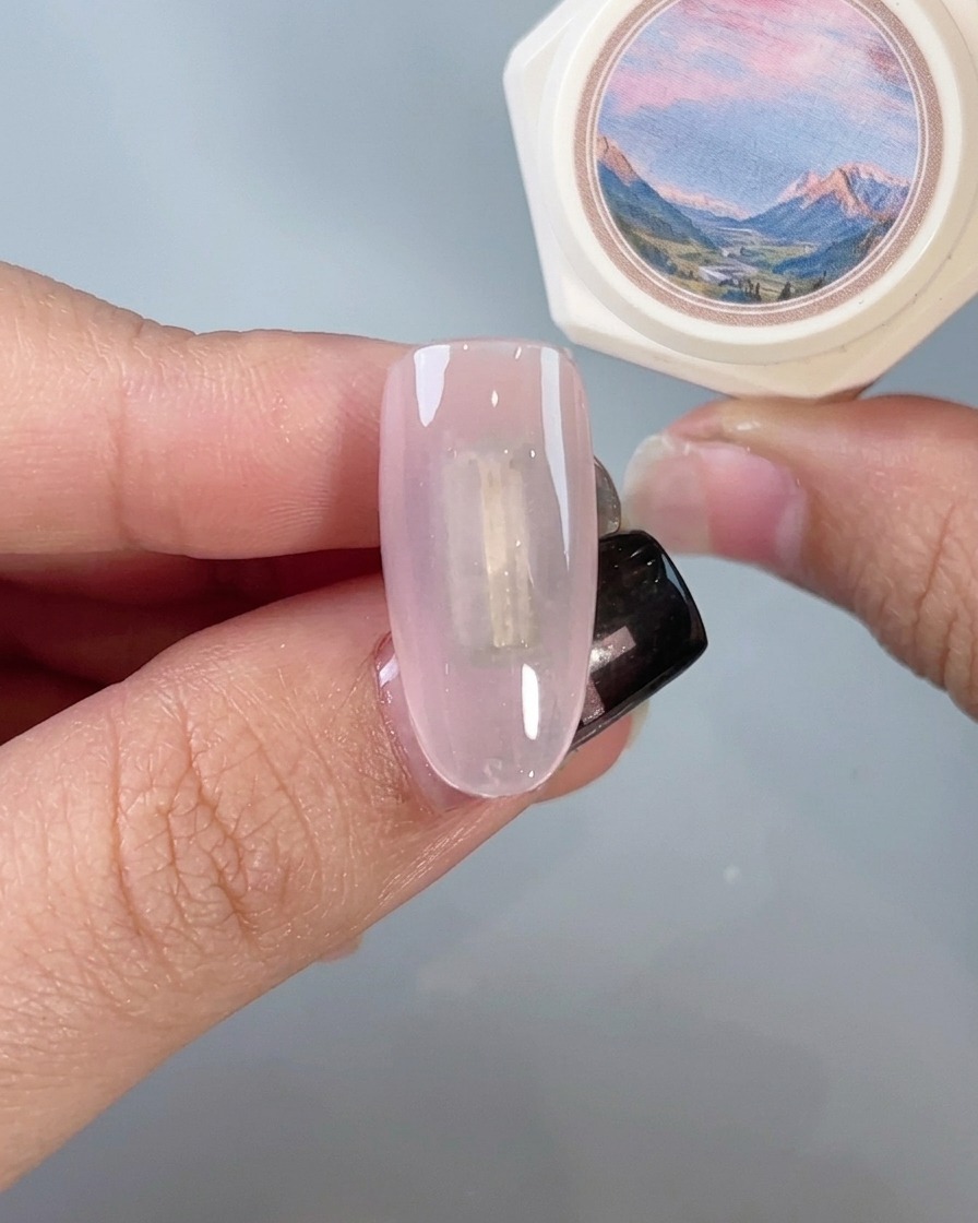 Ein Pinsel trägt einen klaren Top Coat über einen spiegelnden Chrome-Nagel auf.
