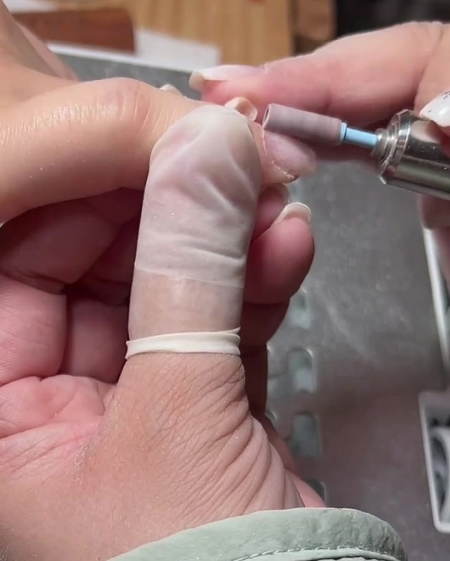 Nahaufnahme eines zylindrischen Fräseraufsatzes, der verwendet wird, um die Haut um den Nagelhautbereich zu glätten.