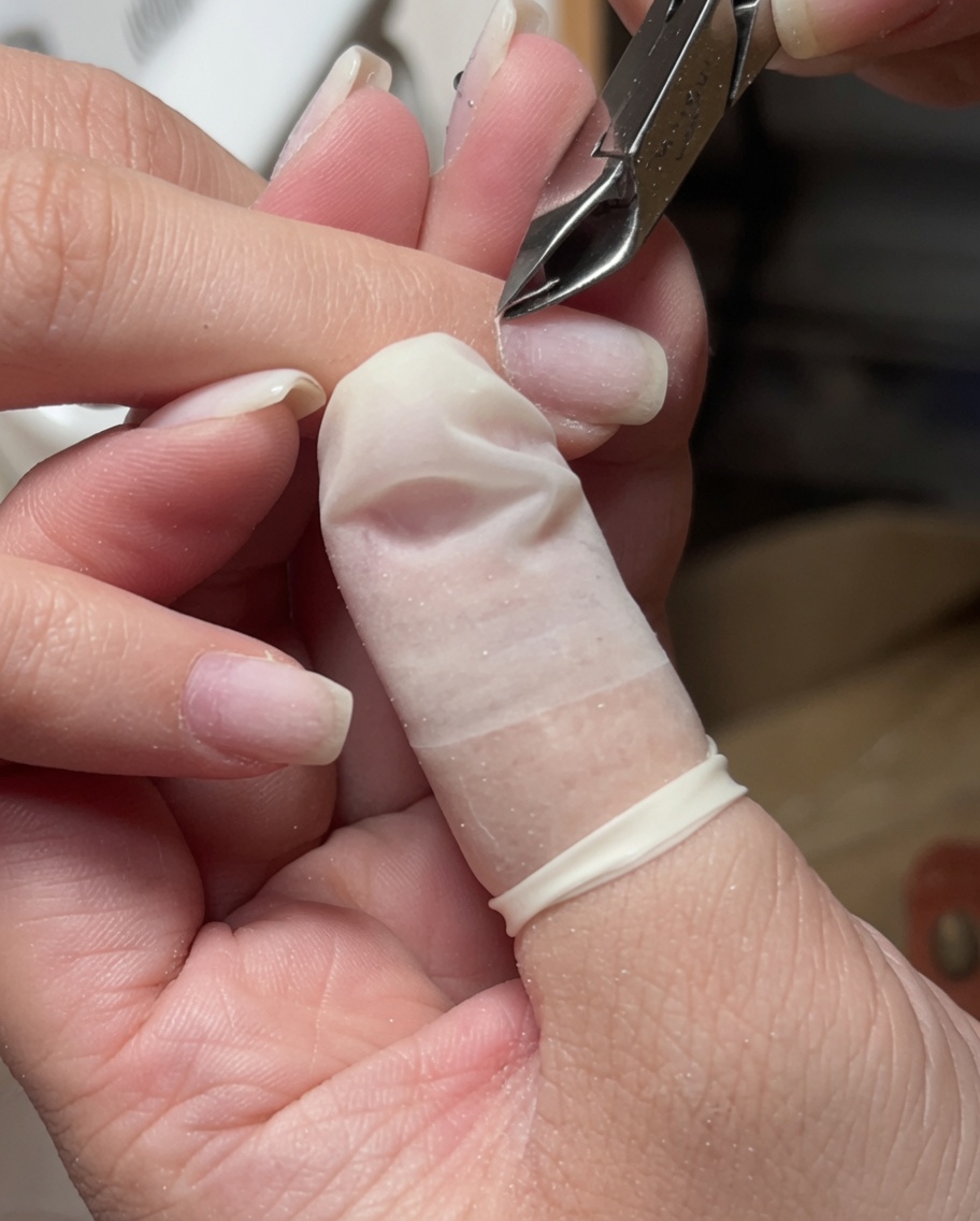 Nahaufnahme einer Edelstahl-Nagelhautzange, mit der lose Haut um die Nagelhaut herum entfernt wird.