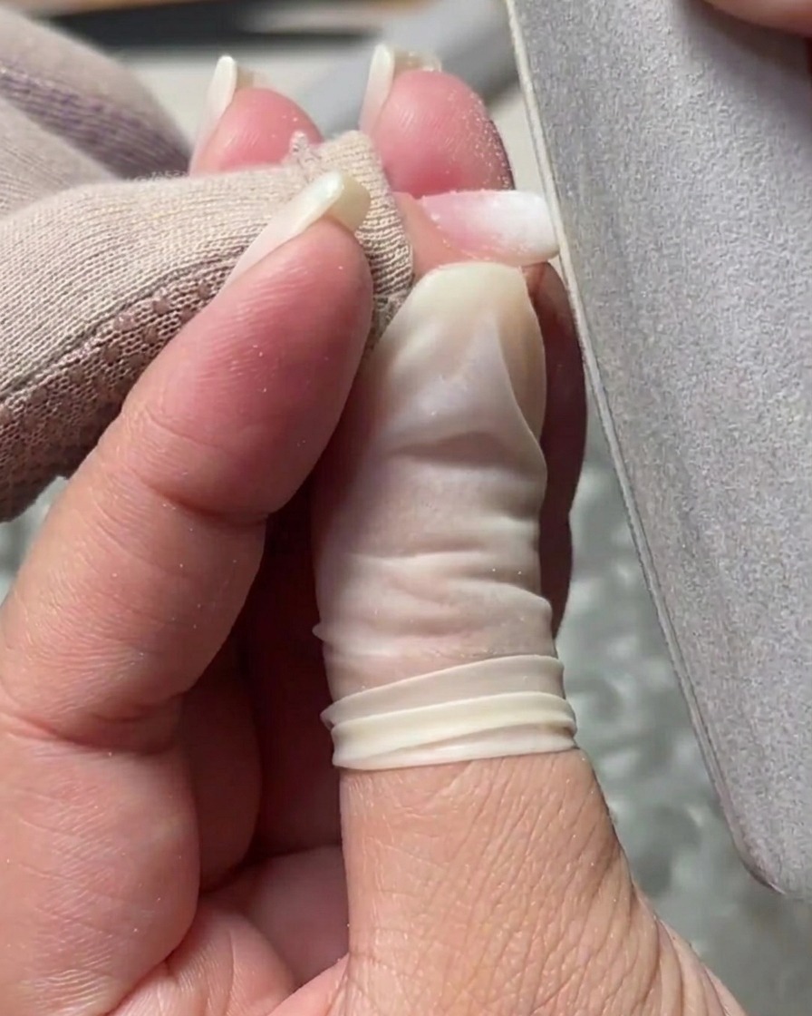 Eine Handfeile wird verwendet, um die Oberfläche zu glätten und die Kanten eines strukturierten Gelnagels zu verfeinern.