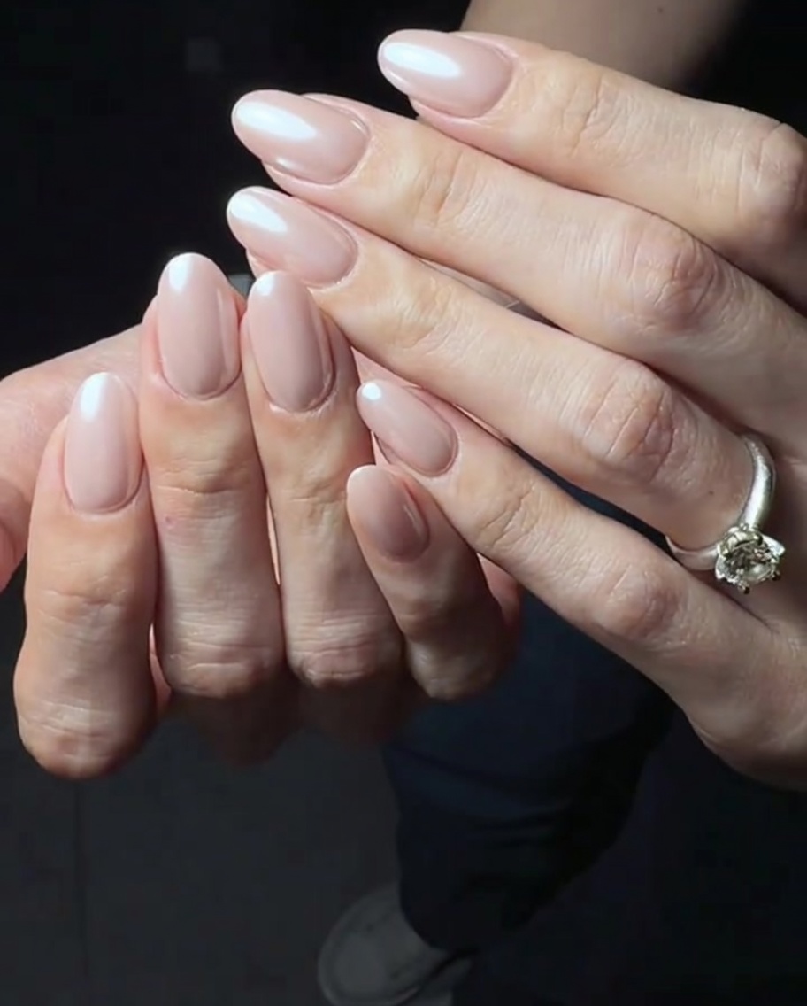 Eine glänzende Schicht Top-Coat wird über die rosa Gelbasis aufgetragen.