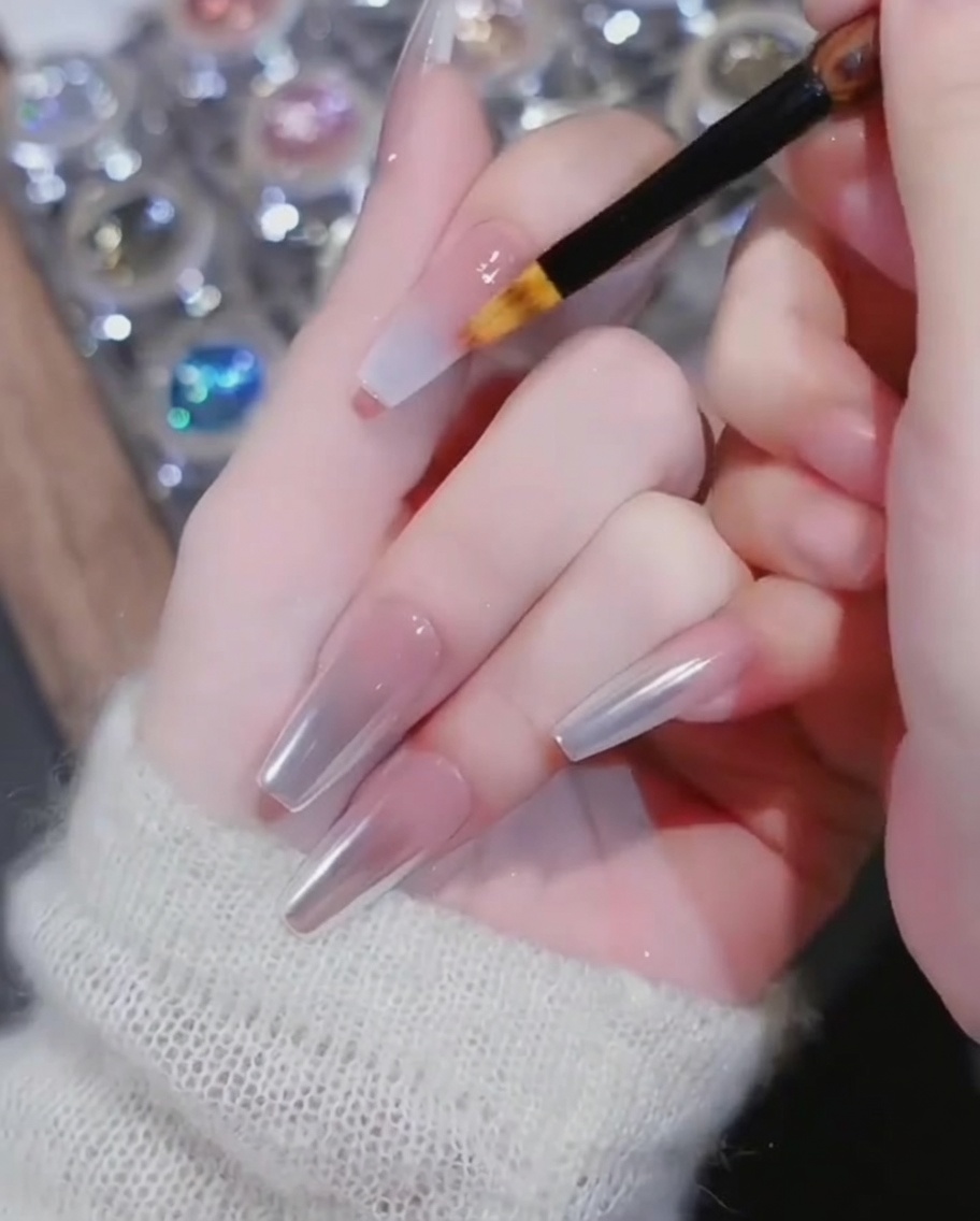 Ein Ombré-Pinsel verblendet den weißen Lack in Richtung des Nagelbettes.