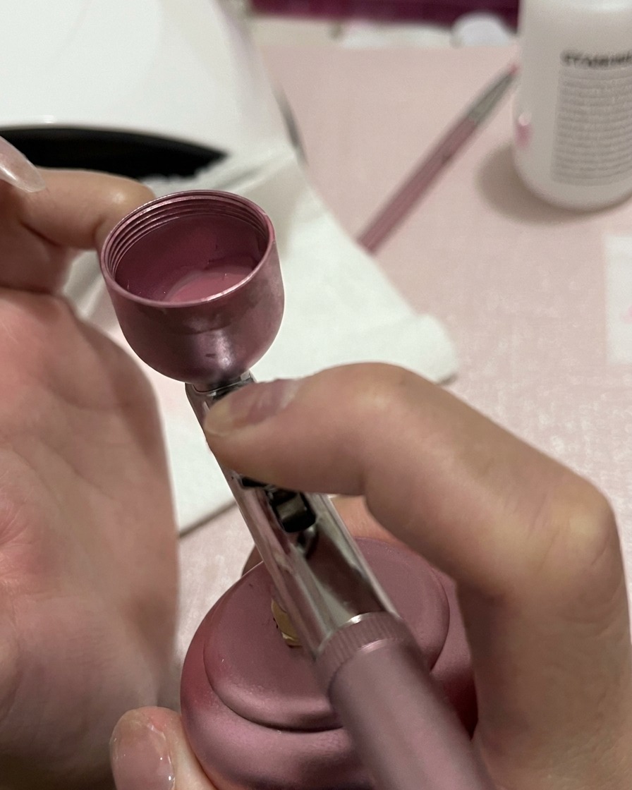 Nahaufnahme eines Nagels, der am unteren Teil eine konzentriertere Schicht rosa Pigment erhält.