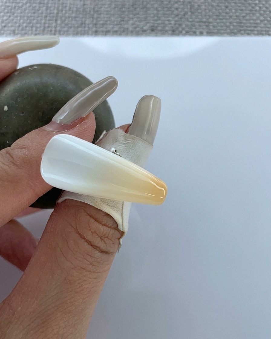 Ein Pinsel trägt klaren Top Coat über den fertigen Airbrush-Gradienten auf.