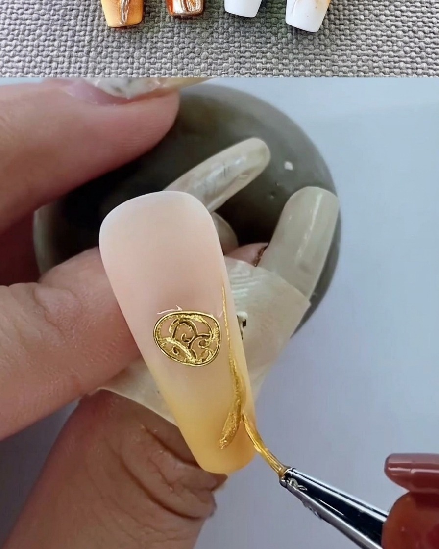 Nahaufnahme eines manikürten Nagels mit Metall-Emblem unter einer UV-Lampe.
