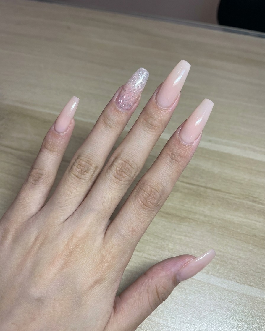 Eine Fachkraft sprüht rosa Farbe aus einer Airbrush-Pistole auf ein Blatt weißes Papier.