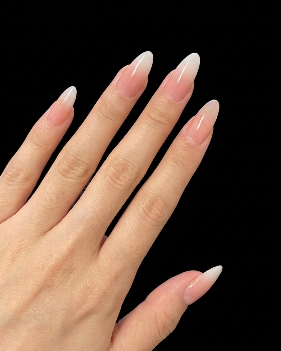 Ein Pinsel trägt eine kleine Menge feinen Silberglitter auf die Mitte eines Nagels auf.